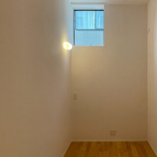 Yさんの部屋は、約３mと高い天井をもつ。壁際にデスクを置き、集中して仕事に打ち込める空間