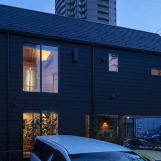 外観夕景。中央の大きな窓は螺旋階段の横に設置されており、室内は見えない。2階奥にはステンドグラスを設置。お施主様の知り合いだというステンドグラス作家の作品だ