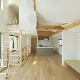 リビングからキッチン方向を見る。菅家さん夫妻の提案で、階段の上部にロフトを設置。収納スペースが増えるだけでなく、ロフトのおかげで天井を高く取ることができ、2階全体が開放的な大空間になった