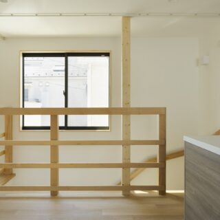ダイニングから階段側を見ると、階段上部の窓から視線が抜け、外とのつながりを感じられて気持ちがいい。2階も階段まわりは光を遮らないシンプルな仕上げ。2階に入る明るい光が階下の1階も照らしてくれる