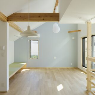 2階。手前がダイニング、奥がリビング。リビングは天井の高い開放空間。天井の梁もほどよく表に出すことで、ナチュラルな木の風合いも楽しめる空間に仕上げている。ブルーグレーの壁のアクセントも爽やかで、ここにいるだけで気持ちまで明るくなる