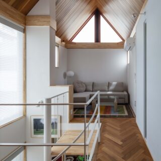 吹き抜けの木材で仕上げられた天井、明るい螺旋階段エリア、大きな三角窓などにより、リゾート感溢れる光景