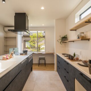 キッチンの床にはタイルを採用。フローリングと比較すると、汚れが染み込まず、すぐに拭き取ることができるのが利点だ。長い間使用しても劣化がなく、キッチンマットも不要。飾り棚には好きな観葉植物などが置かれ、毎日の生活にゆとりをもたらしている