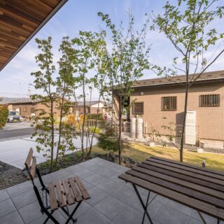テラス上部に張り出した2階は、奥行きがある庇の機能も持つ。隣家が平屋なので、大空の抜けを楽しむことができる。テラスと建物の間にグレーチングを設けることで、排水と換気をしながらリビングと同じ高さのテラスを実現した