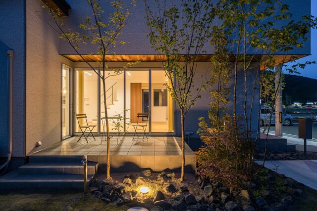 外観夕景。外構は照明とともに設計されているため、夜間でも植栽を楽しむことができる。テラス上部にも照明があるため、外で優雅な時間を過ごすことが可能だ
