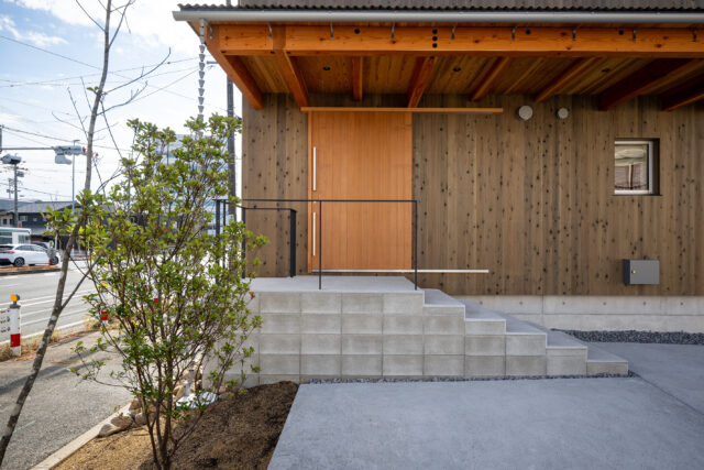 玄関は、コンクリート階段を上った先に。階段部分は建物本体と切り離すことで熱効率やシロアリ対策となるほか、異空間へ飛び込むイメージも。軒を深くとることで建物の構造面の補強にも。
photo：YASUO HAGIWARA