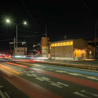 夜でもそれなりの交通量のある国道。室内の明かりが漏れるとともに、２階天井の現しの木組みの美しさがくっきりと見える。
photo：YASUO HAGIWARA