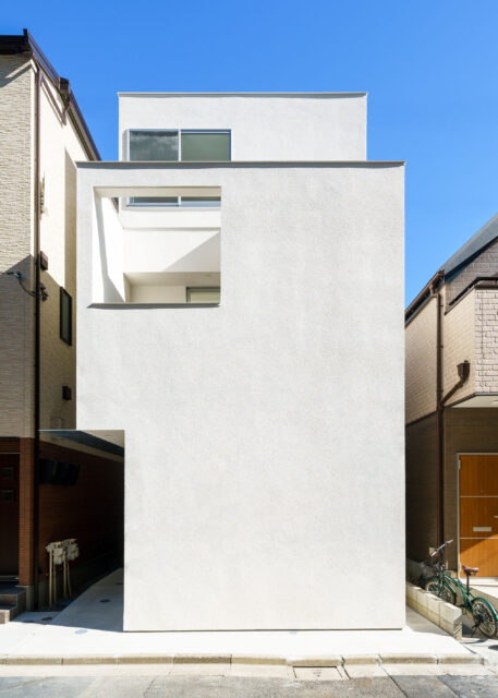 白い箱を２つ重ねたようなシンプルで洗練された外観。道路に面した部分には窓を設けず、玄関も奥まった部分に設けるなどプライバシーに配慮した。バルコニーの開口と３階の窓の大きさを統一するといった、細かな部分にまで保坂さんの美学が貫かれている。