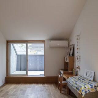 多目的ルームの壁には、吹き抜けに接する小窓を配置。家族の気配を感じることができる。小上がりの先には2階のテラス。秘密基地のような遊び心ある空間だ