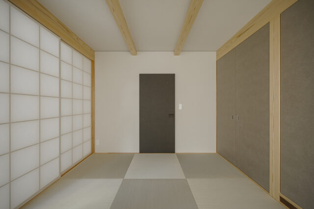 母住居1階和室。廊下からの出入口となる正面の引き戸は鴨居を省き、すっきりした印象に。右に設けた押し入れは、壁面をフラットにするため引き戸ではなく開き戸とした