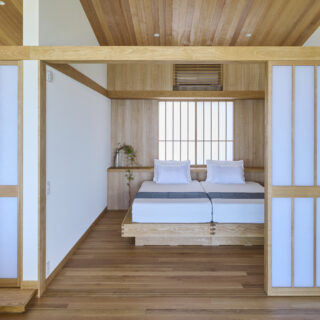 2階寝室。壁面にエアコンを隠し、コンパクトな空間をすっきりと整えた。高級感あるベッドは造作。別荘らしい非日常感を味わえる。東側に計画した窓から朝日が優しく射し込み、気持ちのよい朝を迎えられそう
