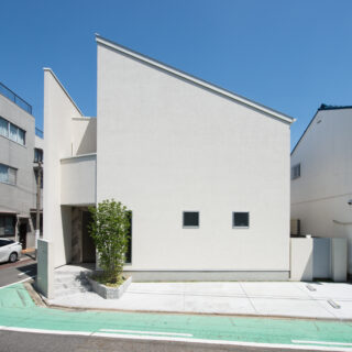 大らかな片流れ屋根のフォルムが印象的な外観。外壁には、わずかに黄色の帯びた白を選択。周囲に馴染みながらも青い空に映える清々しさを演出している。日差しの強い名古屋において、西側に当たるこの面は、西日を防ぐため必要最低限の開口に。抑制されたそのシンプルさが、むしろデザインとして際立っている