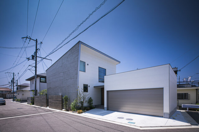 北東から見た外観。住居部分は、道路からの視線が届きにくい北面の高い位置に窓を開口。東の壁面と屋根が大きく張り出しているおかげで、正面からは気配すら感じられない。右の大きな窓は階段のもの。豊かに光を取り込み、家中に届ける