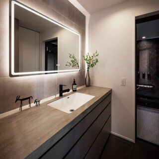 洗面脱衣室、浴室（右奥）。洗濯機を隣接するパントリーに置き、家事動線を短縮しつつ生活感を排除した