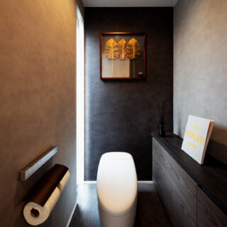 トイレ。左奥のスリットから中庭の光が漏れ入る。日射の変化により壁面の表情も変わる、高級感ある仕上がり