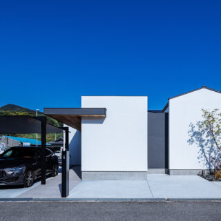 南側から見た外観。ご要望からカーポートを計画、雨に濡れずに家に入れる。来客用の駐車スペースもゆとりを持って配置した。家は箱を組み合わせるイメージでデザイン。できた余白により家が分節され、小さな家が集まった印象に。周囲に馴染むボリューム感を実現した