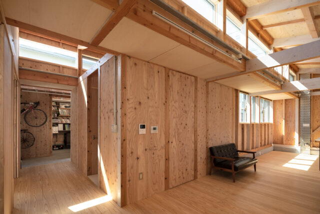 LDKから玄関方向を見る。玄関のさらに奥には土間がある。通路右壁面の仕切りは水回り。各居室と水回りの距離が保たれているかげで、将来は家としてだけでなく複数の利用主体によるシェアなど幅広い用途で改修できる。連なるハイサイドライトからは月も眺められるそう