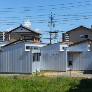 道路側から見た外観。大中小の片流れ屋根が連なる、個性的なフォルム。接道する西面には一切窓を設けずにプライバシーを確保した。基本的にはコンクリート基礎だが、庭と接する箇所などはブロック基礎を採用。拡張や分離など、将来のリノベーションに向けて可能性を広げた