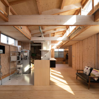 LDKから個室方向を見る。画像左、キッチンの奥は大容量のパントリー。ワンルーム空間のLDK。あらかじめエリアを区切らず、暮らしに合わせて自由自在に使えるよう、照明はレールによる可動式とした