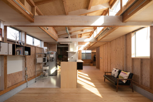 LDKから個室方向を見る。画像左、キッチンの奥は大容量のパントリー。ワンルーム空間のLDK。あらかじめエリアを区切らず、暮らしに合わせて自由自在に使えるよう、照明はレールによる可動式とした