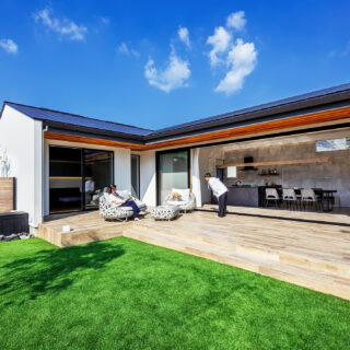 庭から建物を見る。住宅地の一角とは信じられない、リゾートホテルのような雰囲気。建物で西日を遮り、さらに深い庇により日射をコントロールしている。おかげでテラス部分も居場所のひとつになった。隣家が迫る奥側にもハイサイドライトを計画、一年を通して全体に明るくなる