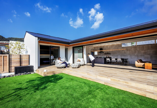 庭から建物を見る。住宅地の一角とは信じられない、リゾートホテルのような雰囲気。建物で西日を遮り、さらに深い庇により日射をコントロールしている。おかげでテラス部分も居場所のひとつになった。隣家が迫る奥側にもハイサイドライトを計画、一年を通して全体に明るくなる