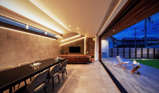 LDK(左)、テラス(右)。勾配天井は最高3.7mの天井高があり、開放感抜群。天井に極力照明を設けず、ライン状に配置した間接照明によって明るさの確保とデザイン性を両立させた