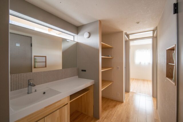 洗面は廊下と兼用とし、ゆとりを確保。大きな鏡の上には自然光が入るようにした。壁をマグネット対応とすることで利便性も高い。