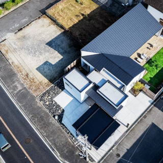 家を上空から見る。クローゼット、ゲストルーム、水回り、居住空間とエレメントごとに分け、それぞれを収めた箱を組み合わせたフォルム。それによってできた余白に大小２つの庭を計画した。黒い屋根部分が寛ぎの場。左に走る幹線道路から離し、プライバシーを確保した