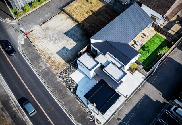 家を上空から見る。クローゼット、ゲストルーム、水回り、居住空間とエレメントごとに分け、それぞれを収めた箱を組み合わせたフォルム。それによってできた余白に大小2つの庭を計画した。黒い屋根部分が寛ぎの場。左に走る幹線道路から離し、プライバシーを確保した