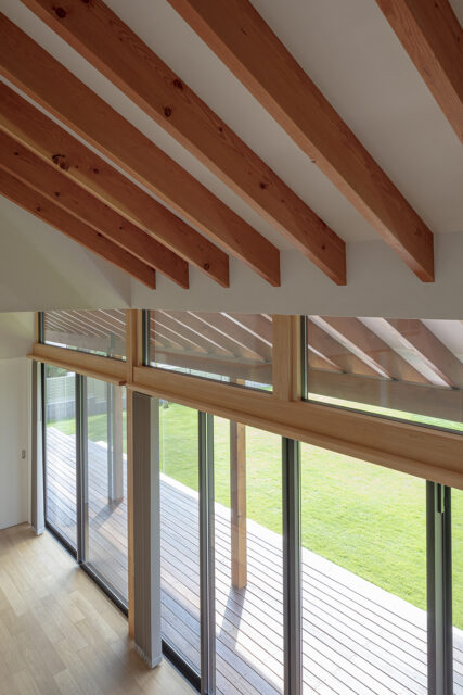 軒までのびた垂木が屋外との一体感を強調。ウッドデッキにかかる深い軒は夏の直射を遮る効果もある
