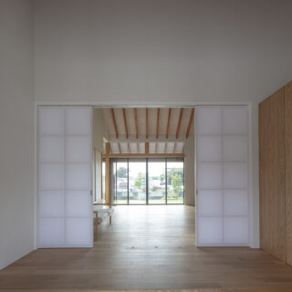 天井は高いがコンパクトな玄関ホール。障子戸を開けると垂木の先の庭まで一気に視線が抜け、開放感に感動
