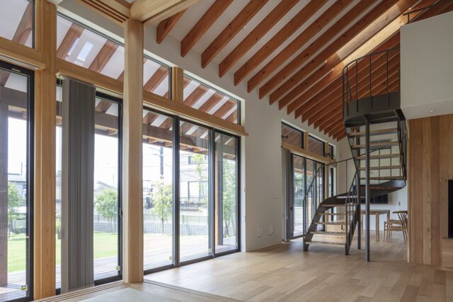 オブジェのような階段でリビング(手前)とダイニング(奥)をゾーニング。南は大きく開口し、要望の1つだった「日当たり、風通し」も実現。写真右に進むと勝手口に続く廊下や玄関があり、風が気持ちよく通る。天井には複数の天窓を設け、上からの採光や上下の風の流れも確保