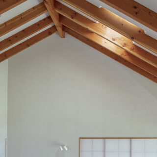 天窓から入る光が垂木に当たると、黄金色を帯びて白壁に映る美しい光景に出合える。リビングは梁をかけなくてもいいように、30cmの高さがあるしっかりした垂木で支えているが、「全部見えると重いので」と、半分ほど天井で覆ってバランス良く仕上げた