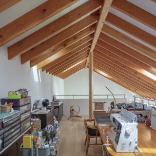 奥様の趣味はパッチワーク。大型の作品をつくれるよう、２階に専用のワークスペースを設けている。独立した秘密基地のようで集中できるが、周囲は壁で仕切らず手すり壁にしているので、1階とのつながりもキープされて気配がそれとなくわかる