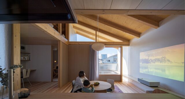 現しの屋根と室内から伸びるカウンターによって、その先の広い空へと視線が抜けていく。壁を磨き漆喰仕上げの壁の仕上がりをみたSさんは、テレビを壁掛けにせず、プロジェクターで投影することにし壁の連続性を活かすことにしたという。