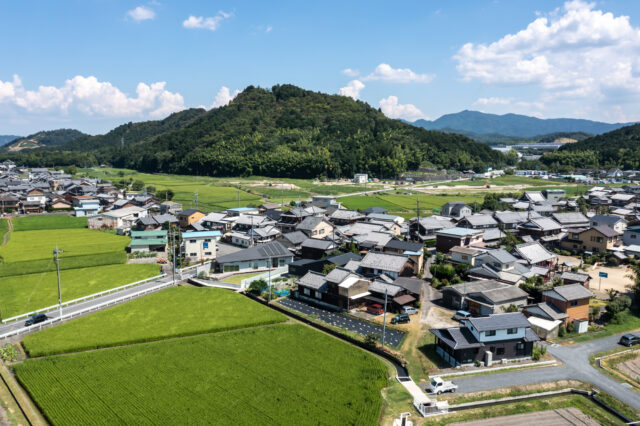 近江富士と呼ばれる三上山を背後に持つ、旧中山道の古い街並み。周辺環境との調和を考え、一部2階建てだが平屋のように見えるデザインを採用。近隣家屋でも採用されている切り妻屋根や、似た色を採用することで違和感や威圧感をなくした