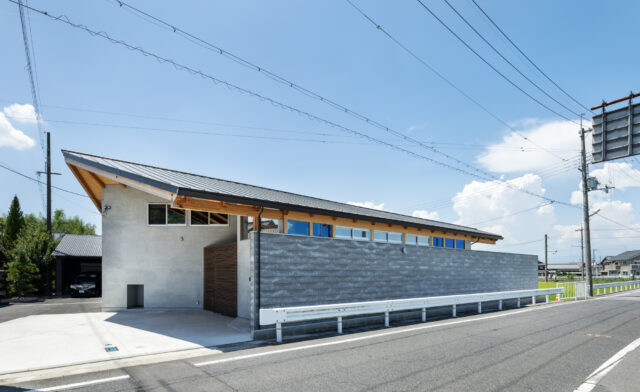 子どもの安全面を考慮し、前面道路側に大きな壁を設置。周辺への威圧感が出ないように、デザイン上の工夫もなされている。壁と屋根、そしてその間のスリットの窓に分割し、それぞれの位置・角度・色を計算することで軽やかな印象を持たせた