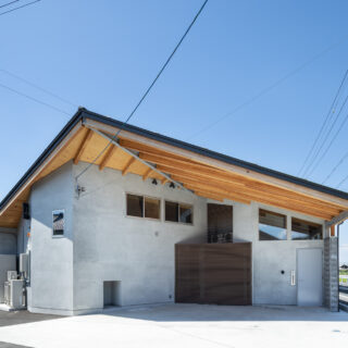 壁の奥まった位置に玄関ドアがあるため、子どもが道路に飛び出す危険はない。大きな軒下は、屋根付きのカーポートの役割も持つ。棟木に向かって取り付く登り梁が、船の竜骨のようで迫力があり美しい