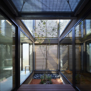 ビル用サッシを用いて実現した中庭の大開口。上部やルーバーからの光や風を導く。
中央に植えられたもみじも、季節感を与えてくれる存在。夏にはこのデッキでお子さんがプール遊びを楽しんだという。
