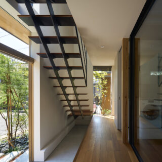 横に伸びる玄関土間は自転車置き場にも。靴箱を配し、靴は上り框の中へ収納。図らずも子どもやご近所さんが腰掛けて休憩する現代の縁側になったという。