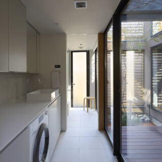 洗面所は、造作カウンターの中に洗濯乾燥機をビルトイン。カウンター上部の開口から、洗濯物やゴミを投入できるようにし、すっきりした空間と使い勝手を実現した。