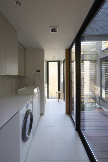 洗面所は、造作カウンターの中に洗濯乾燥機をビルトイン。カウンター上部の開口から、洗濯物やゴミを投入できるようにし、すっきりした空間と使い勝手を実現した。