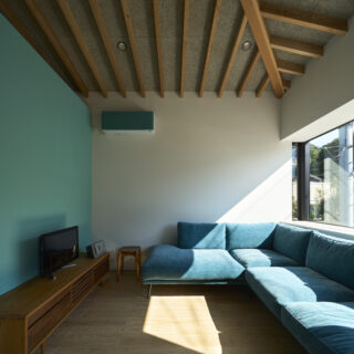 お気に入りのソファに合わせ、出窓の高さ、壁やエアコンの色を統一。垂木の現しで天井の美しさも演出した。