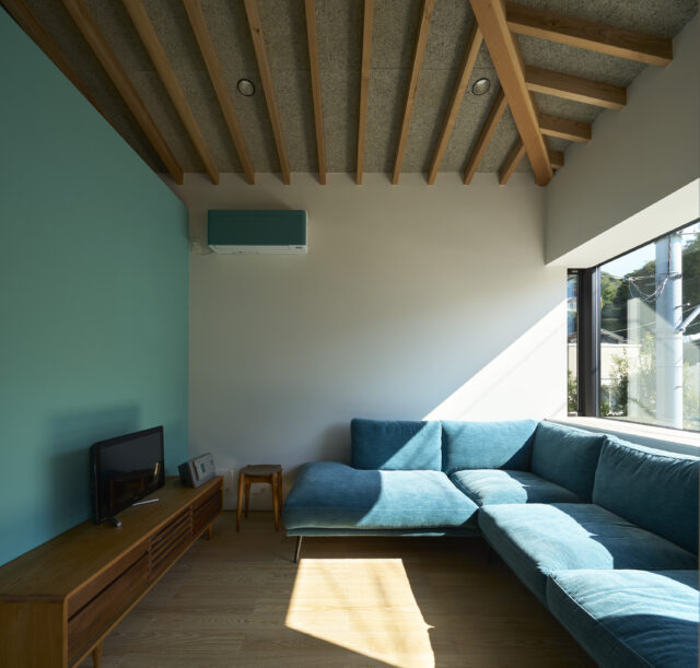 お気に入りのソファに合わせ、出窓の高さ、壁やエアコンの色を統一。垂木の現しで天井の美しさも演出した。