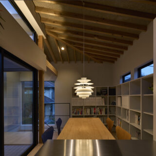 本棚も窓の高さにピッタリ合わせて造作。ルイスポールセンのランプが、上質な空間に一層の雰囲気をもたらしている。