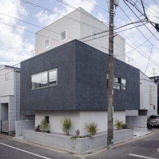 世田谷の閑静な住宅地の角地に建つM邸。白とグレーの３つの箱が積み重なる洗練されたフォルム。3面に等しく窓を配置しバランスも整えた。
