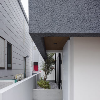 玄関へのエントランスは、通りからの視線を遮るよう、実家との境界に設けた。実家との行き来もしやすい配置。