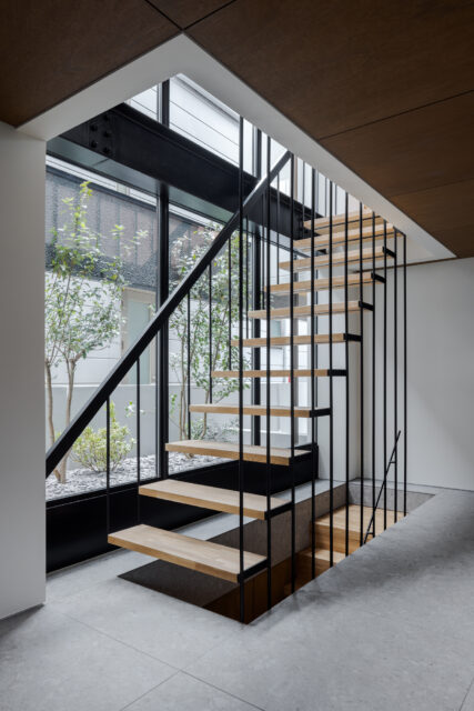 スケルトンの鉄骨階段は光を遮らないよう吊り構造で。オブジェのような美しさを放っている。窓の先には木々が植えられ、この家と共に成長し、やがて心地よい木陰を生み出すことだろう。