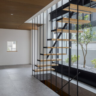 広々とした玄関ホールは、タイル張りの床と白い壁が織りなす洗練された空間。１階は水回りを集約。扉は取っ手のない仕様で壁と一体化。空間の美しさを損なわないよう配慮した。